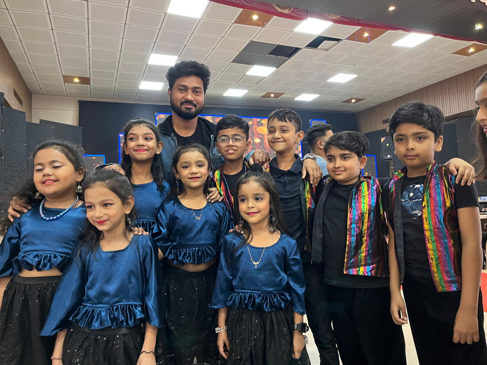 Young performers in matching blue and black costumes